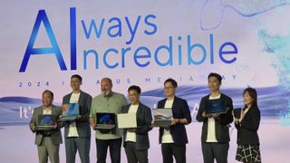 Asus staff on stage holding the new laptops including the Zenbook S 14 and Vivobook S 14