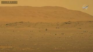 This still image from NASA's Perseverance rover on Mars shows the Mars Helicopter Ingenuity hovering above the Martian surface during its historic first flight on April 19, 2021. 