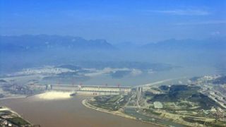 Enormous dam stretches across vast expanse of water.