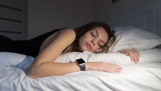 Sleeping woman wears a sleep tracker on wrist