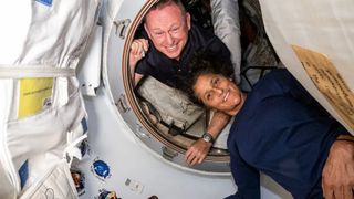 A photo of a man and a woman floating in a space ship