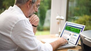 A person using a laptop to check up on their Windows hosting options.