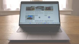 Asus ExpertBook P5 (P5405) open on a wooden table showing the Laptop Mag home page