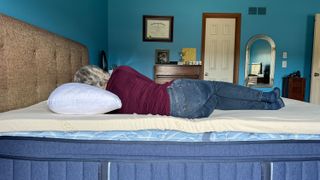 A person lying on the Naturepedic Adagio 2" Organic Latex Mattress Topper