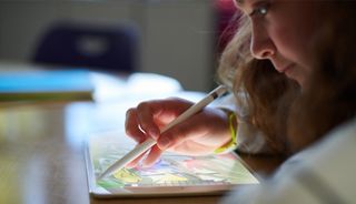 A young girl using an Apple iPad with Apple Pencil 