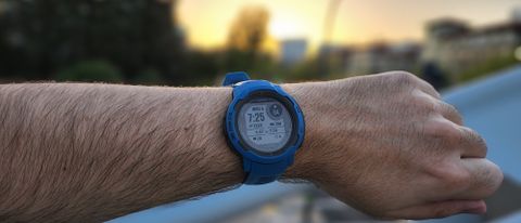 The Garmin Instinct 2 Solar backlit by a sunset