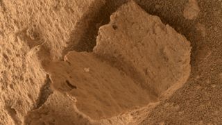 top down view of a rock on mars that has a shape like an open book