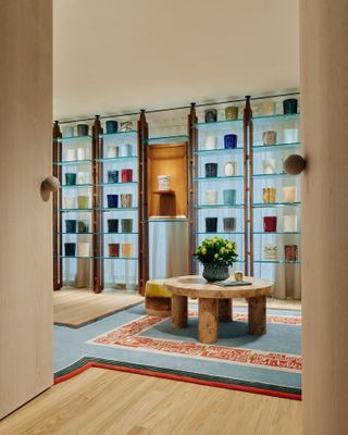 Shelves in Maison Diptyque London displayed coloured ceramic candles