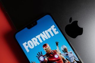 Fortnite vs Apple. Game login screen from Epic Games seen on the smartphone placed on ipad. Epic Games vs Apple lawsuit concept.