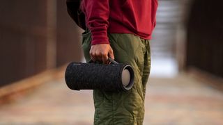 Man holding Sony SRS-XG300 Bluetooth speaker from handle.