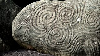 a cylindrical stone covered with overlapping circles from close up