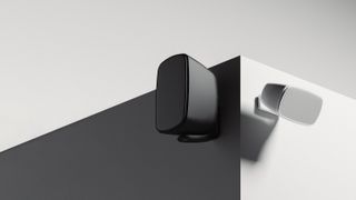 Two speakers (one black, one white) mounted on external walls.