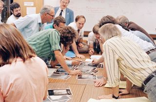 Members of the Voyager science team look at new images of Neptune's moon Triton as information from NASA's Voyager 2 probe comes down to Earth in August 1989.