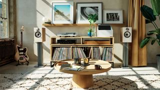 Bowers &amp; Wilkins 606 S3 speakers on stands either side of a console bearing a record player and shelves of vinyl