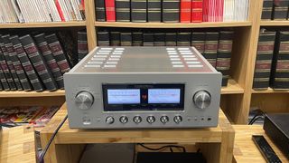 Luxman L-509Z integrated amplifier on wooden hi-fi rack in front of bookcase