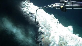 An underwater robot taking water samples for a black smoker vent