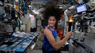 NASA astronaut Suni Williams holds a mock torch aboard the International Space Station to celebrate the start of the 2024 Summer Olympics.