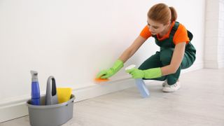 Woman spraying baseboard