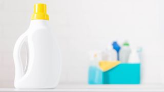 White bottle of bleach with cleaning products in blue box