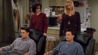 Joey and Chandler sitting in recliners, Monica and Phoebe standing behind the chairs.