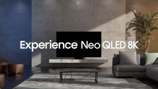 The Samsung QN700A sits on a marble counter by a sofa, with 'Experience Neo QLED 8K' written across image