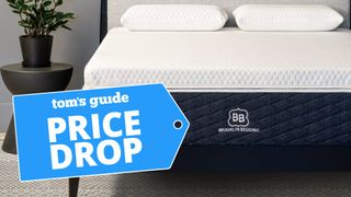 The Brooklyn Bedding Microcoil Topper on a bed with price drop sale label