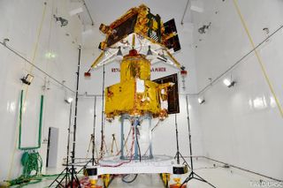 a spacecraft in a big testing chamber with white walls