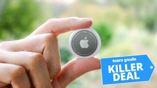 A photo of an Apple AirTag held between the user&#039;s fingers, with the &quot;Tom&#039;s Guide killer deal&quot; tag overlaid