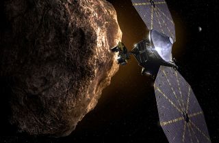 An artist&#039;s depiction of the Lucy spacecraft studying an asteroid.