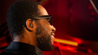 Cory Henry wearing Beyerdynamic's new pro-specific IEMs, sitting at a piano