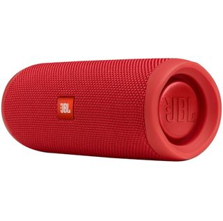 A red JBL Flip 5 speaker on its side against a white background.