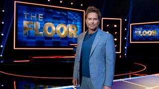 Rob Lowe, host of new Fox gameshow &quot;The Floor&quot;, stands in a glitzy TV studio in front of screens displaying The Floor logo. 