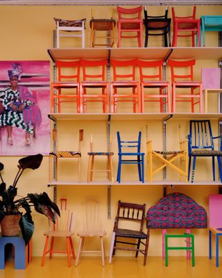 Rows of colourful chairs inside the studio of designer Yinka Ilori