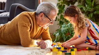 Adult and child playing with toys. 10'000 Hours via Getty Images