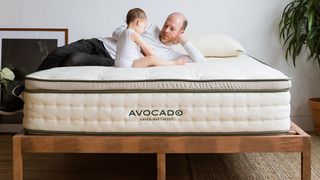 Best king size mattress image shows a man and a baby sitting on the Avocado Green mattress
