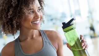 Woman using water bottle at gym