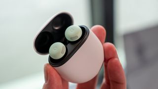 Holding the green Google Pixel Buds Pro 2 in their case