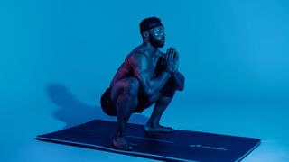 Obi performing a low sumo squat with his hands in prayer