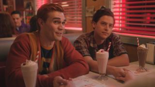 Archie and Jughead holding Betty's hand at Pop's in the Riverdale series finale.