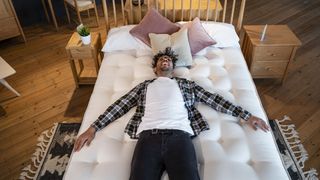 Man lying on a firm mattress for back pain in a mattress showroom