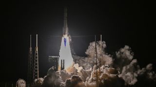 a vulcan centaur rocket launching into the black nighttime sky.