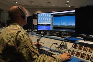 Mark Conque sits at a desk with a large computer screen in front of him displaying the launch pad.