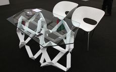 Glass gallerists’ table with white legs and chairs legs