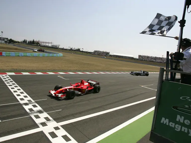 Michael Schumacher crosses the line in first place at the 2006 French Grand Prix.