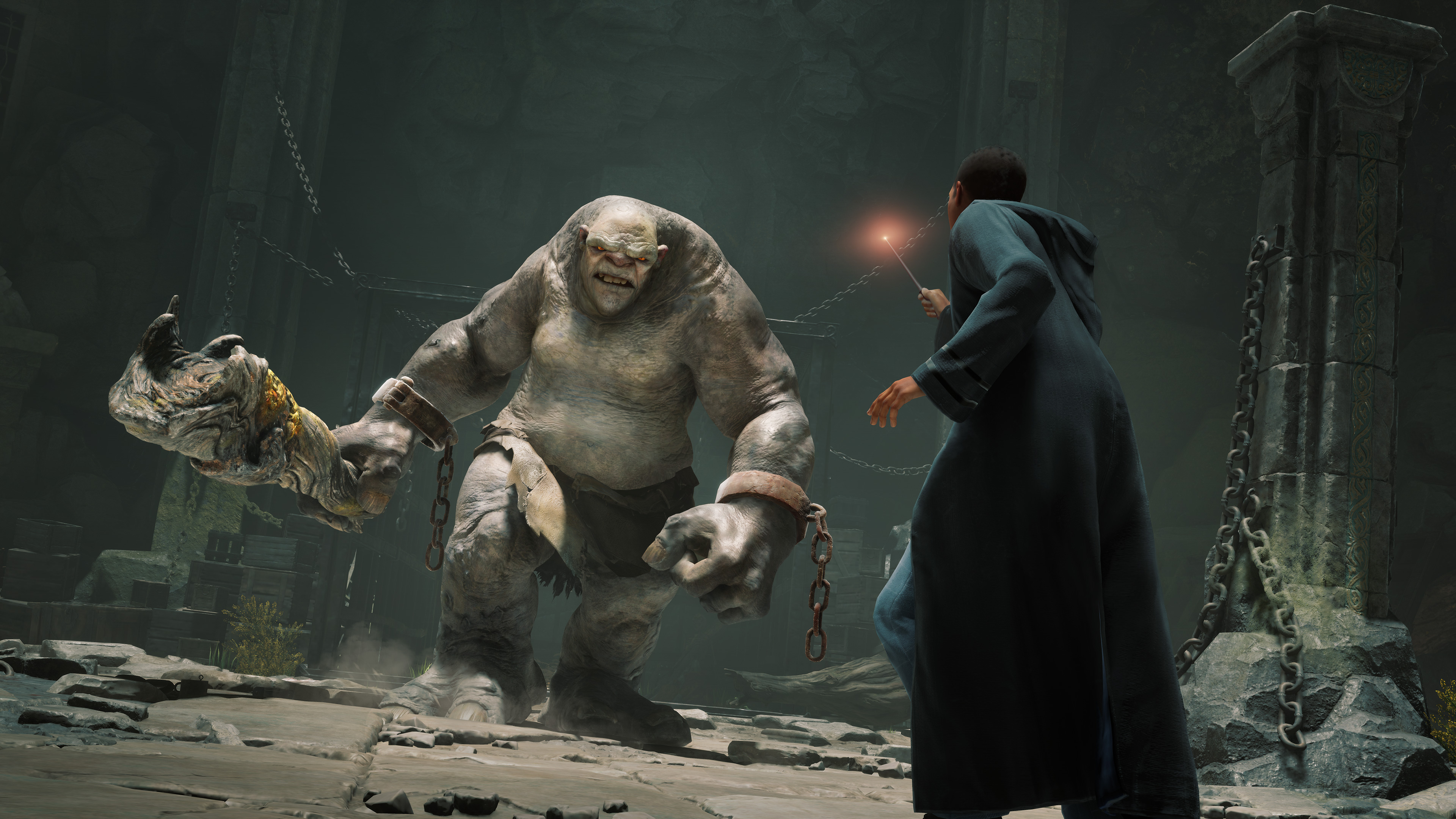 a Hogwarts student brandishes his wand as a troll advances toward him in Hogwarts Legacy