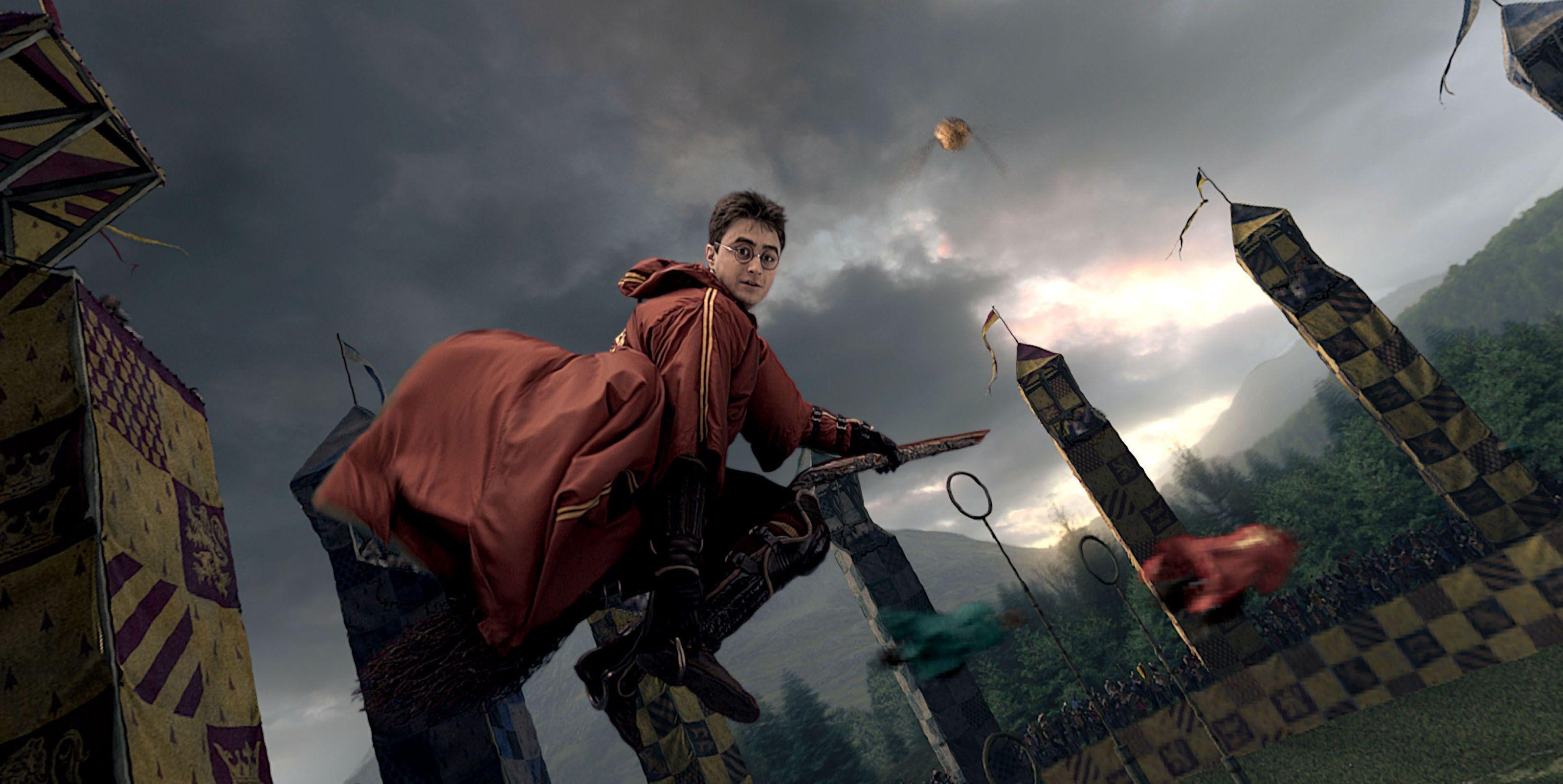 Harry Potter flying on a broom in his quidditch uniform