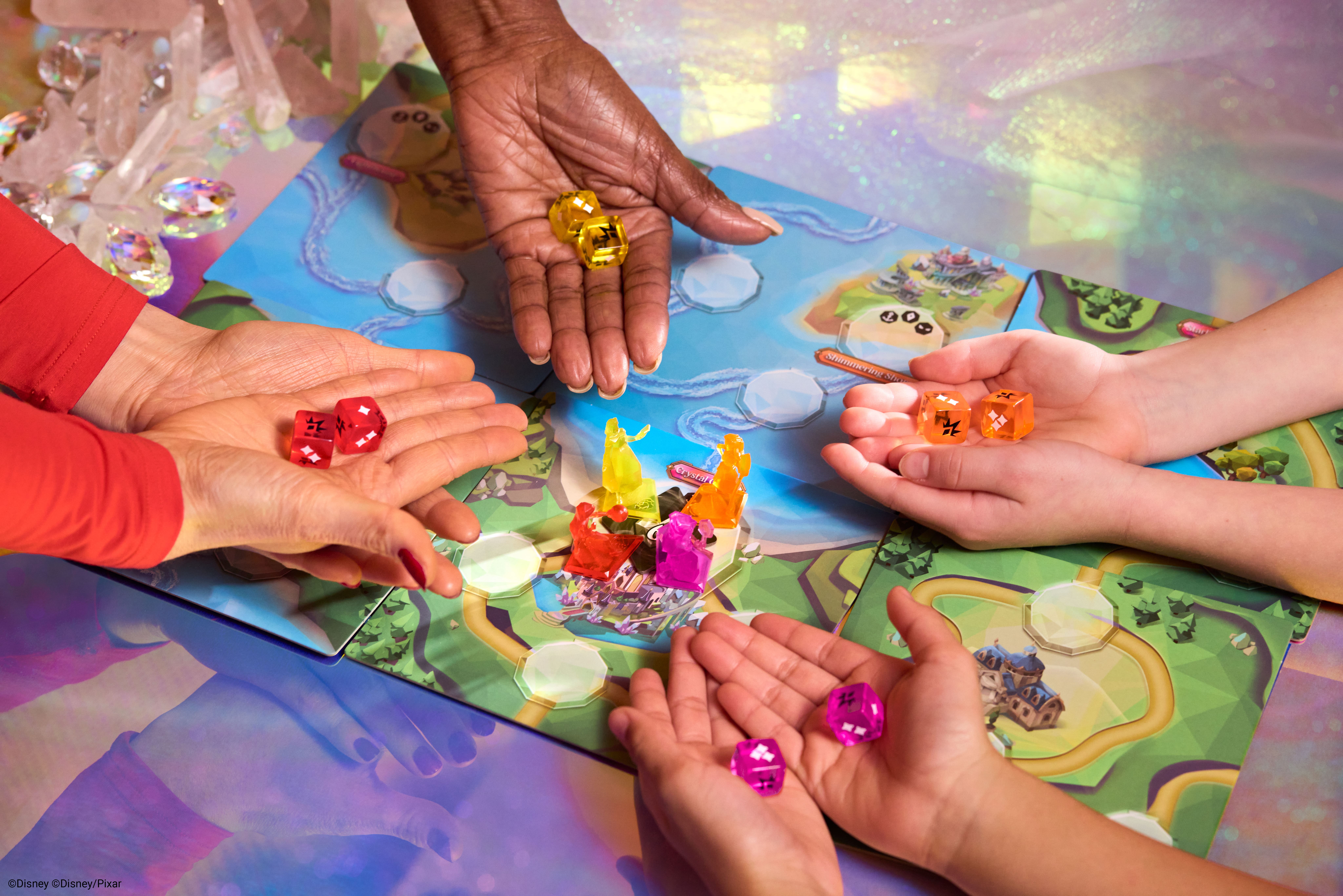 Four pairs of hands each hold out a pair of colorful dice over a board game