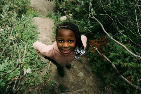 Young girl smiling in the trees.