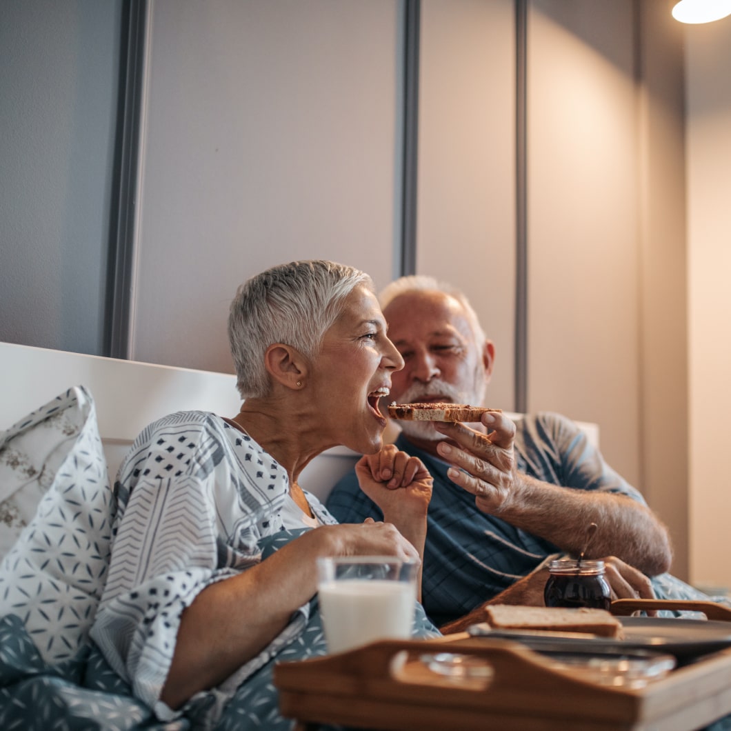 Um casal a tomar o pequeno-almoço na cama