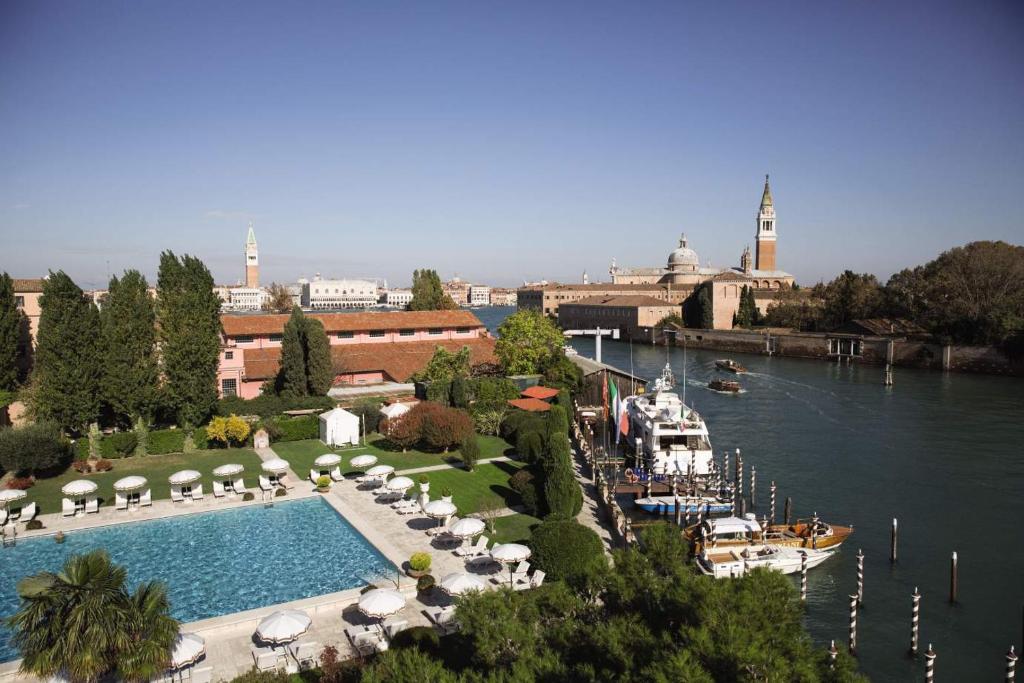 ein großer Pool neben einem Fluss mit Booten in der Unterkunft Hotel Cipriani, A Belmond Hotel, Venice in Venedig